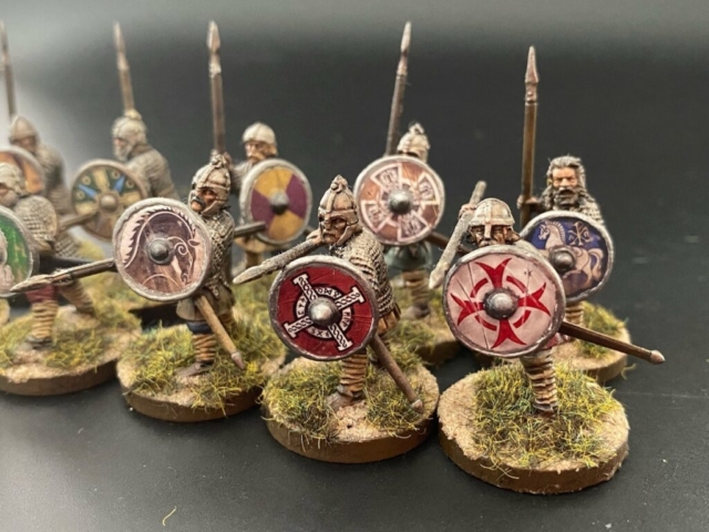 Group of saxon thegn figures with shields and weapons.