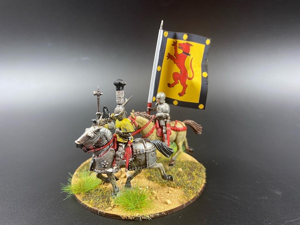 2 horsemen mounted on round base, one figure carrying large banner.